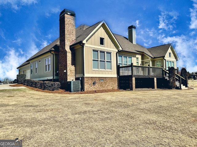 view of side of property featuring roof with shingles, a chimney, board and batten siding, crawl space, and a garage