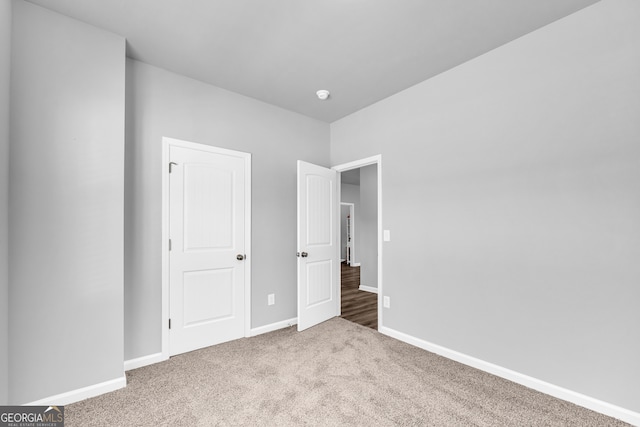 unfurnished bedroom featuring carpet flooring and baseboards