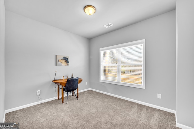 carpeted office space featuring baseboards and visible vents