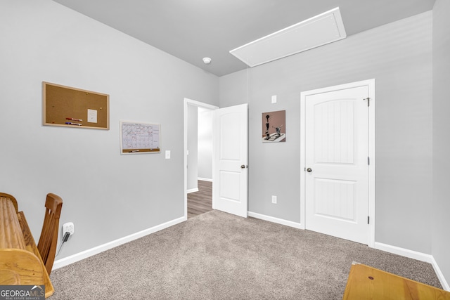 carpeted bedroom with attic access and baseboards