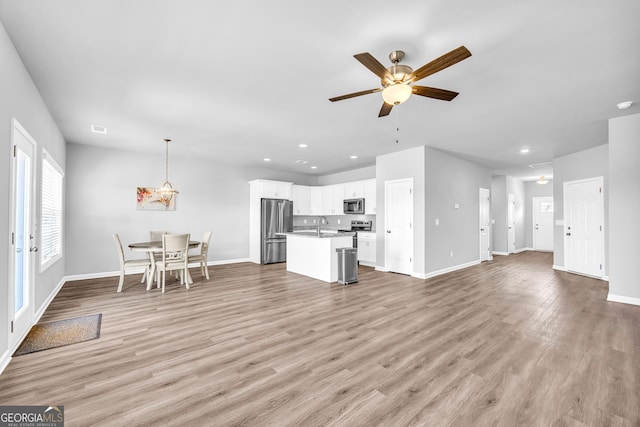 interior space featuring light wood-style flooring, a ceiling fan, and recessed lighting