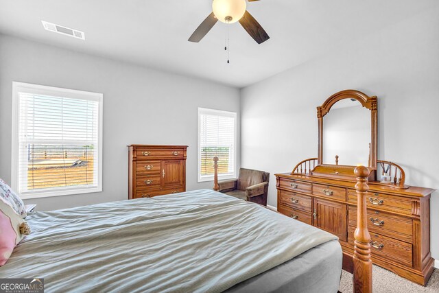 carpeted bedroom with ceiling fan and visible vents