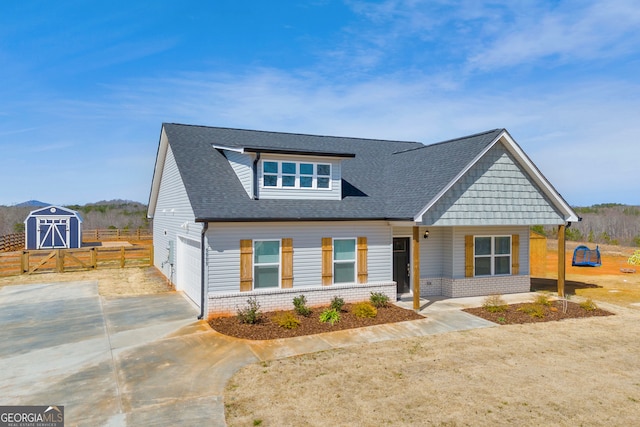 view of front of home with driveway, a shingled roof, fence, and brick siding