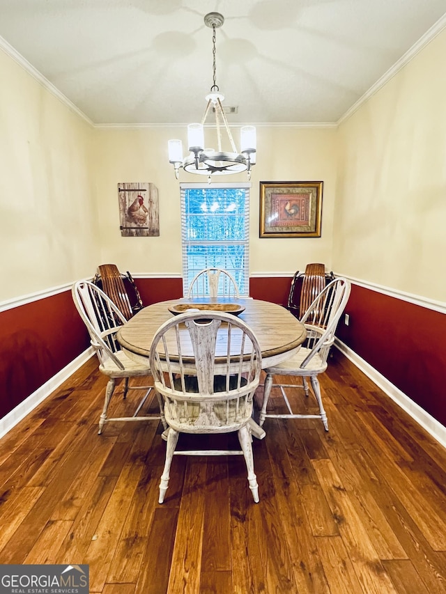 dining space featuring baseboards, ornamental molding, a chandelier, and hardwood / wood-style floors