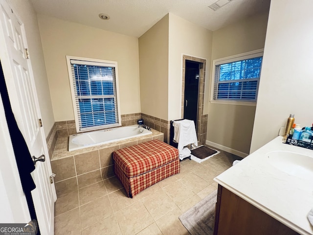 bathroom featuring double vanity, tile patterned floors, a sink, a shower stall, and a bath