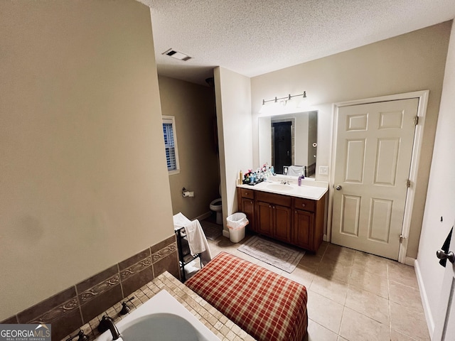 full bathroom featuring visible vents, toilet, tile patterned flooring, a textured ceiling, and vanity