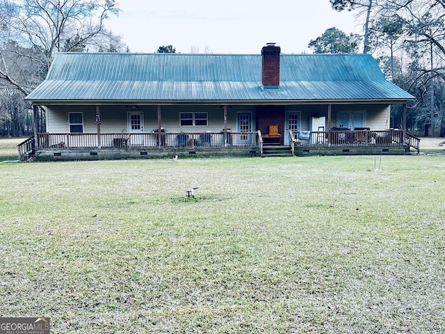 farmhouse with metal roof, a porch, crawl space, a front lawn, and a chimney