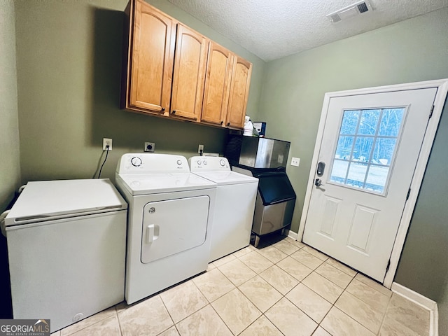 washroom featuring visible vents, cabinet space, light tile patterned flooring, a textured ceiling, and independent washer and dryer