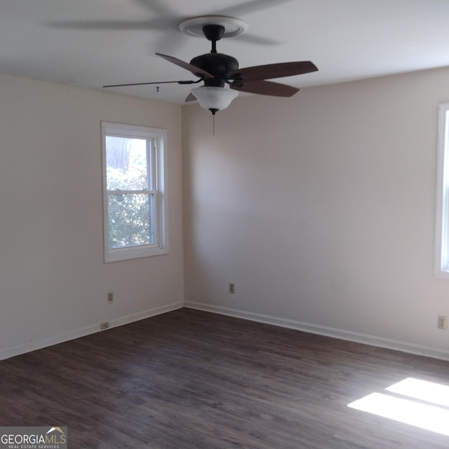 empty room featuring ceiling fan, baseboards, and wood finished floors