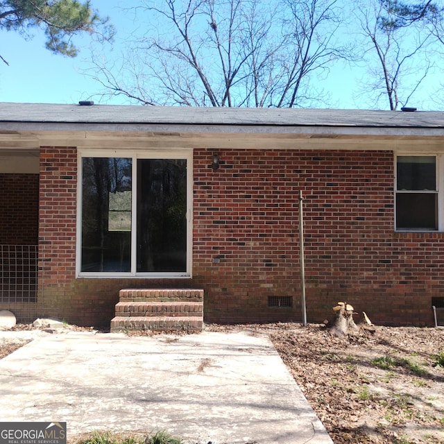 view of home's exterior featuring entry steps, brick siding, and crawl space