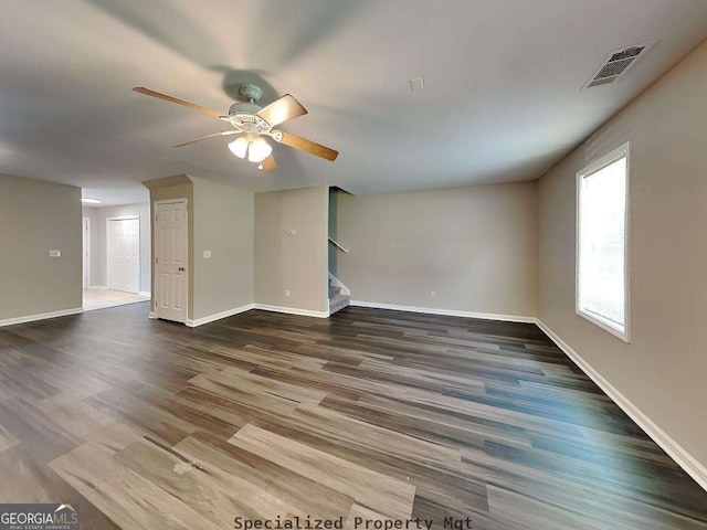 unfurnished living room with wood finished floors, visible vents, baseboards, and stairs