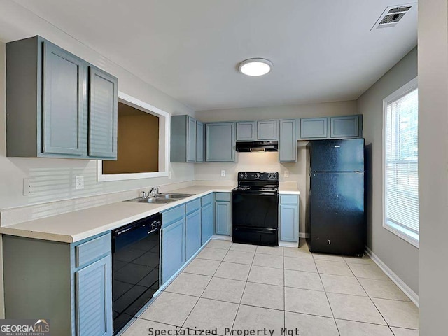 kitchen with black appliances, ventilation hood, light countertops, and visible vents