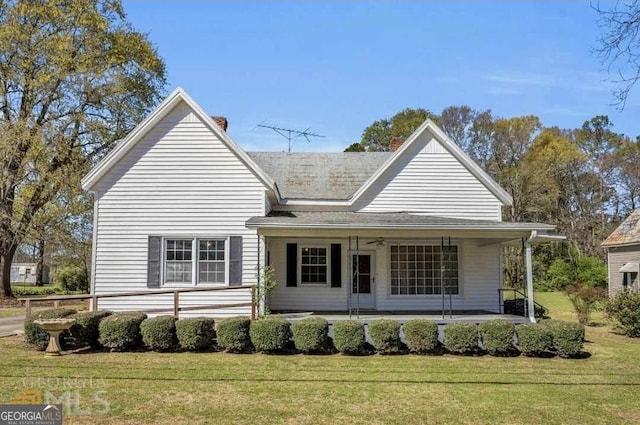 view of front facade with ceiling fan and a front lawn