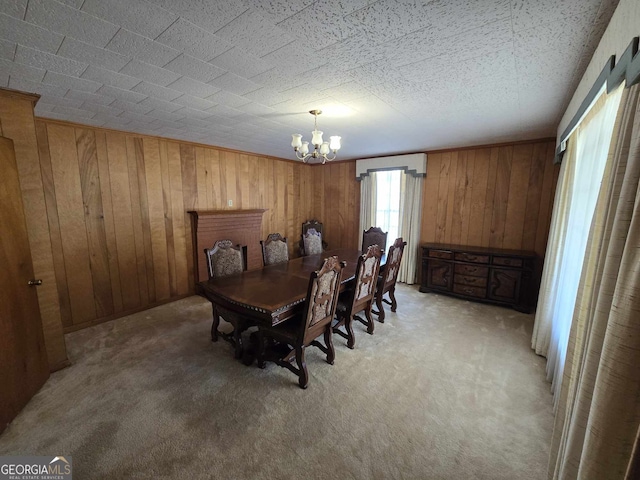 dining room with wooden walls, a notable chandelier, and light colored carpet