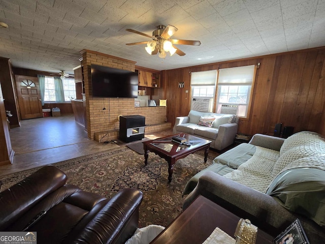 living room with ceiling fan and wooden walls