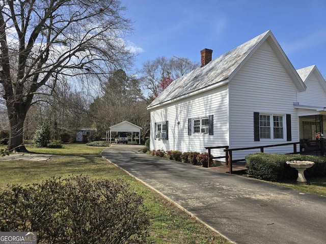 view of side of property with a lawn and a chimney