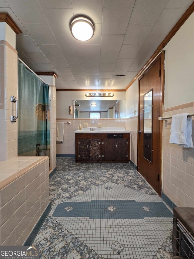 full bath with crown molding, tile walls, a shower with shower curtain, and vanity