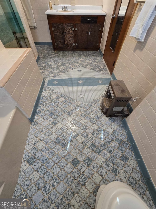 full bath featuring tile patterned floors, a shower, tile walls, and vanity