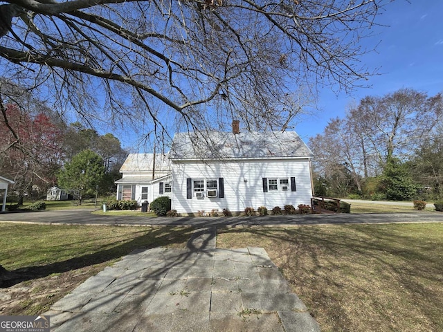 new england style home featuring a front lawn