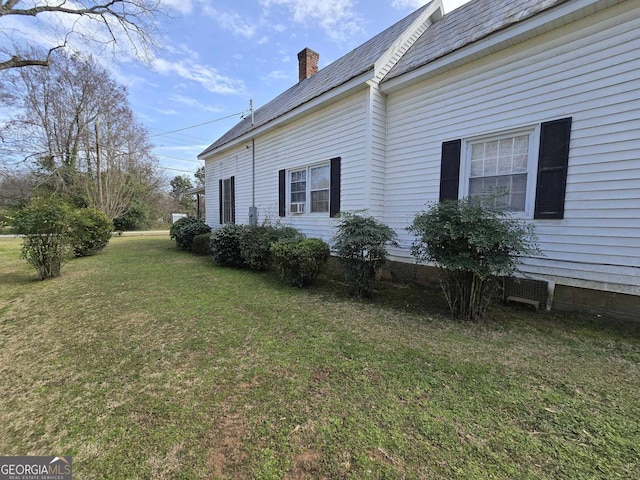 view of side of property featuring a yard and a chimney