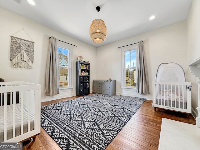 bedroom featuring multiple windows, baseboards, hardwood / wood-style floors, and recessed lighting