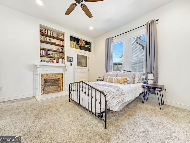 carpeted bedroom with a fireplace with raised hearth, recessed lighting, a ceiling fan, and baseboards