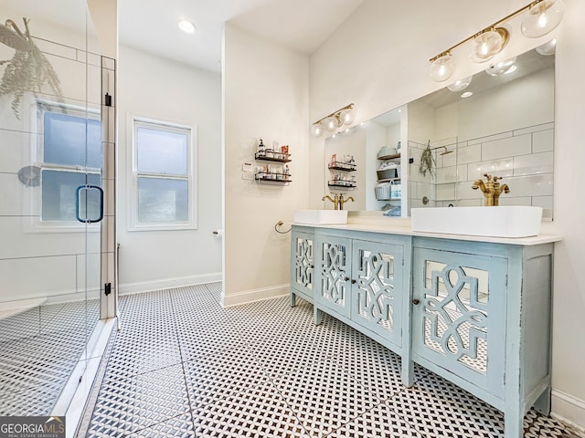 bathroom featuring double vanity, a stall shower, and baseboards