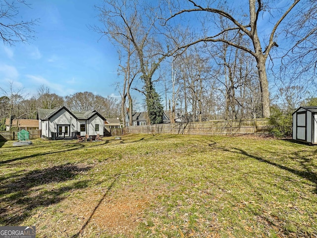 view of yard with a fenced backyard, an outdoor structure, and a shed