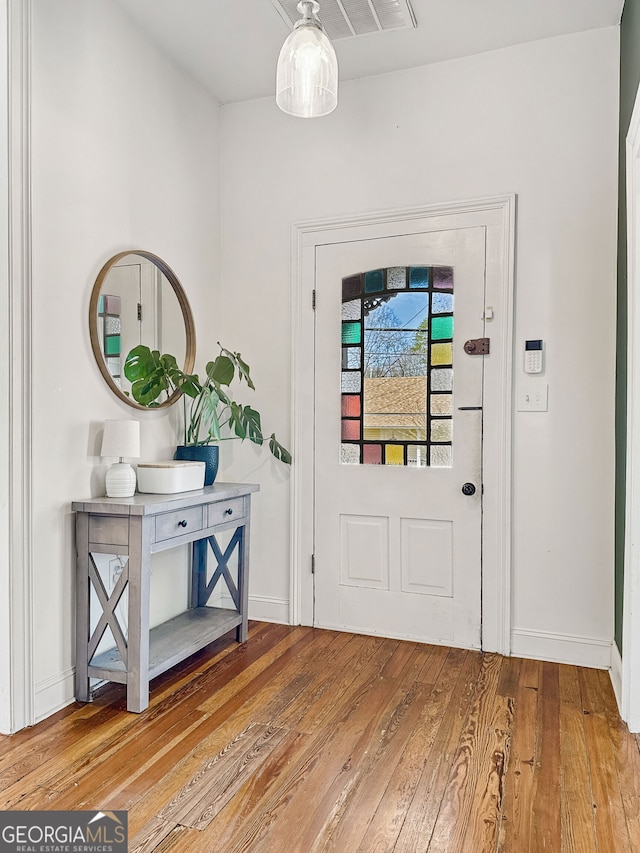 foyer entrance featuring visible vents, baseboards, and hardwood / wood-style flooring