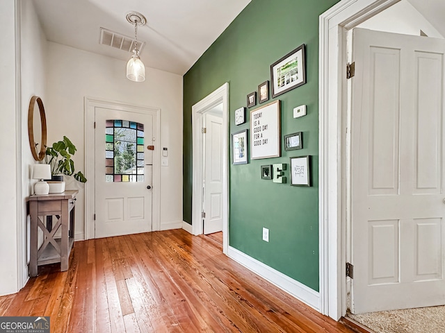 entryway with light wood finished floors, baseboards, and visible vents