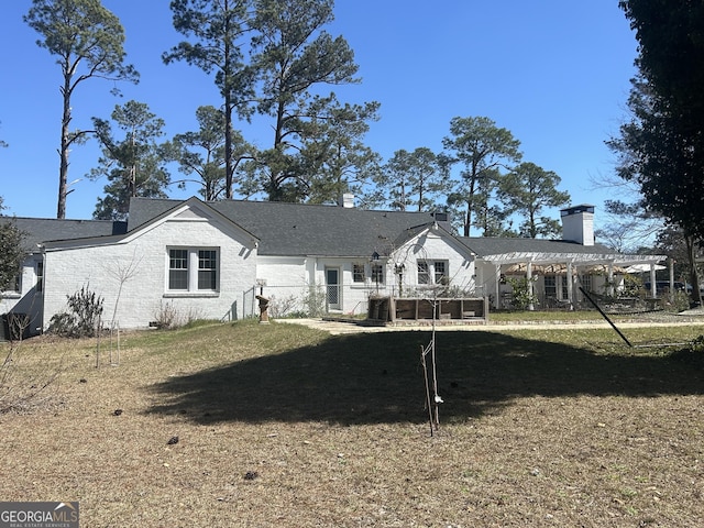 rear view of property with a chimney and a pergola