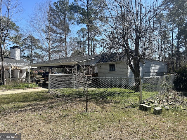 back of property featuring an attached carport, fence, and driveway