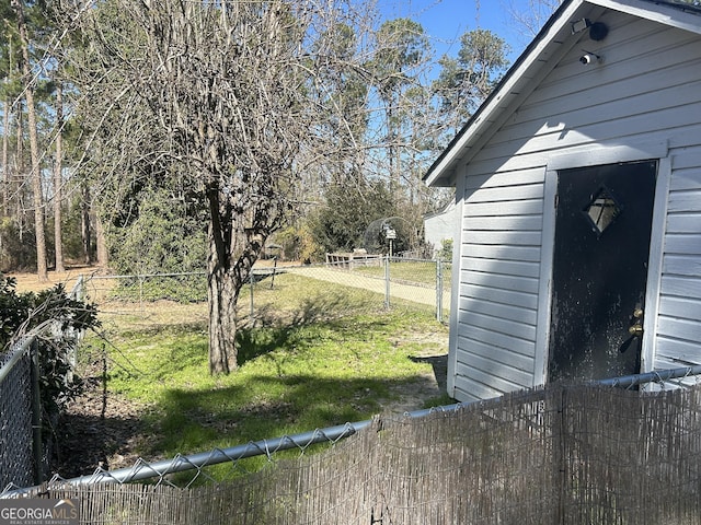 view of yard featuring a storage unit, an outdoor structure, and a fenced backyard