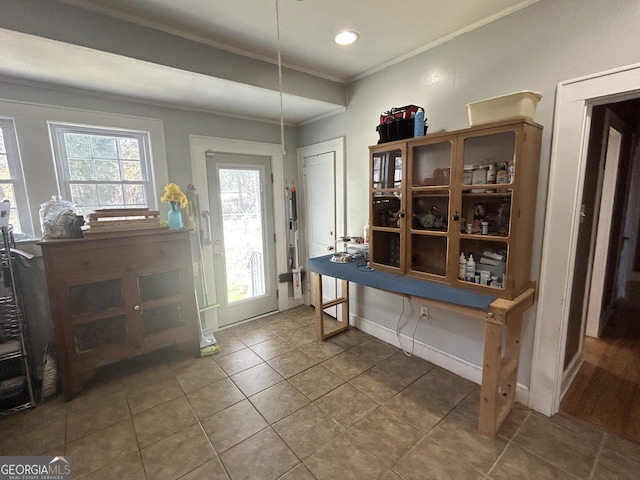 entrance foyer featuring tile patterned flooring, crown molding, baseboards, and a wealth of natural light