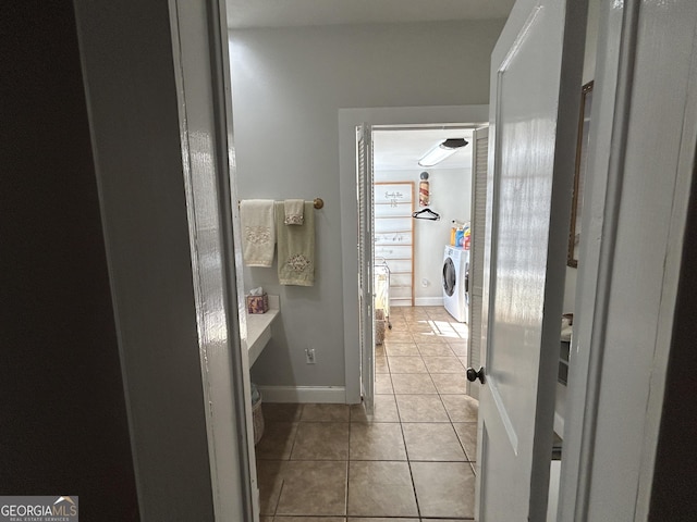 bathroom with tile patterned flooring, washer and dryer, and baseboards