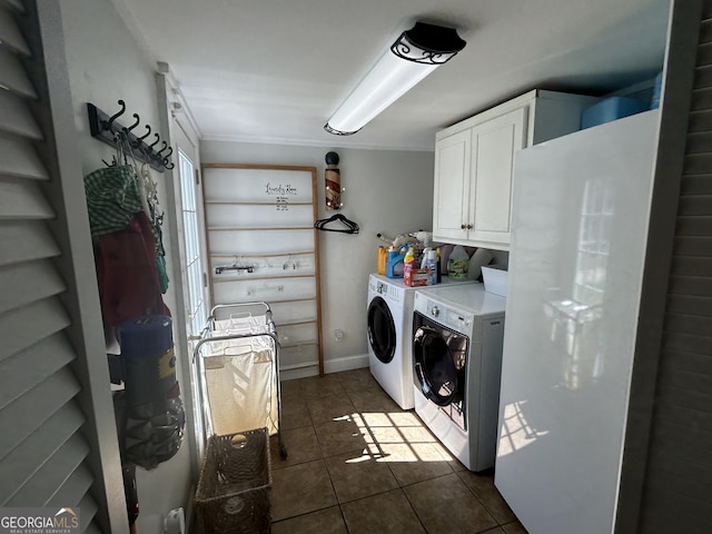 laundry room with washer and clothes dryer, cabinet space, baseboards, and dark tile patterned floors