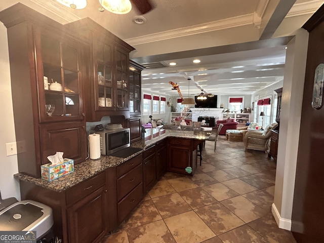 bar with tile patterned flooring, stainless steel microwave, crown molding, beam ceiling, and a fireplace