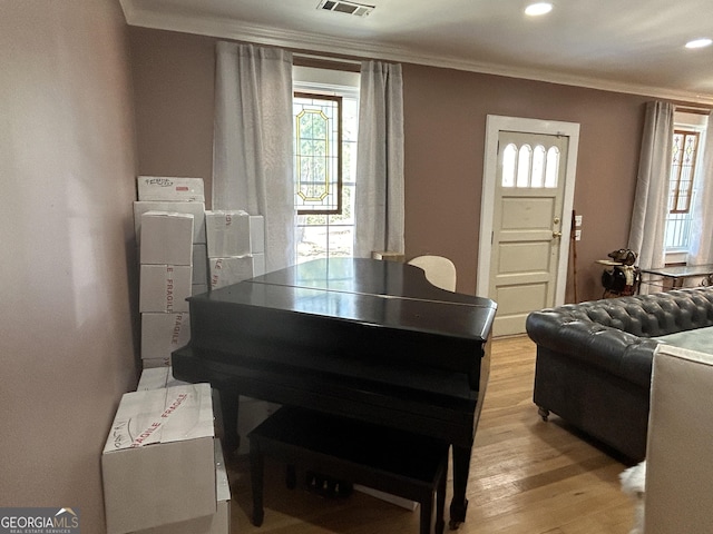 living room featuring recessed lighting, visible vents, light wood-style floors, and crown molding