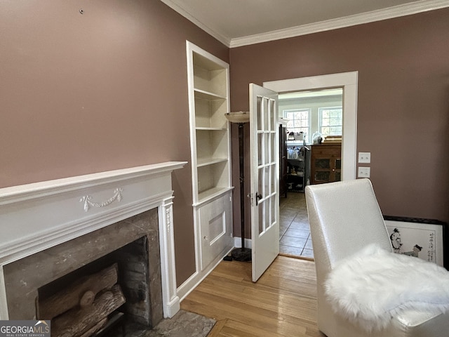 interior space featuring light wood-style floors, ornamental molding, and a fireplace