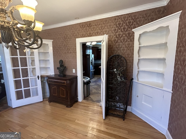 dining space with a notable chandelier, light wood-style flooring, and wallpapered walls