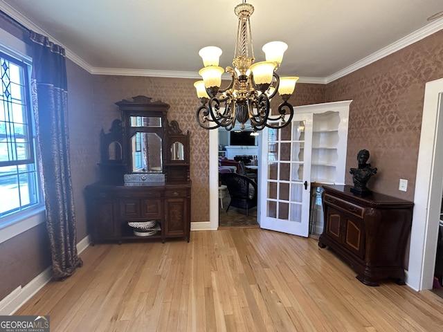 dining room featuring wallpapered walls, crown molding, light wood finished floors, baseboards, and a chandelier