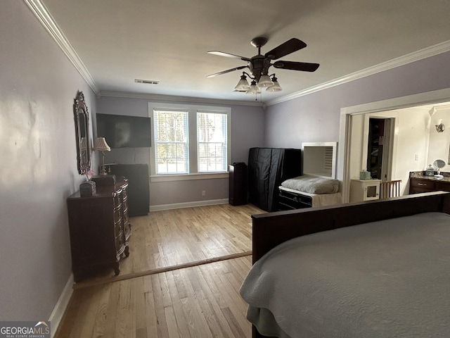 bedroom featuring visible vents, ornamental molding, a ceiling fan, wood-type flooring, and baseboards