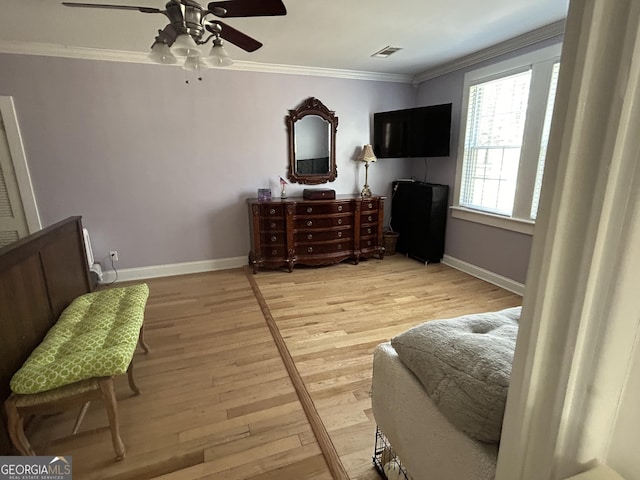 bedroom with light wood finished floors, ceiling fan, crown molding, and baseboards