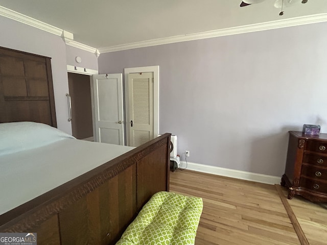 bedroom with light wood-style flooring, baseboards, and ornamental molding