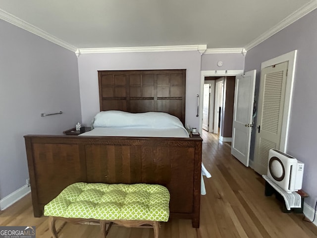 bedroom with crown molding, baseboards, and wood finished floors