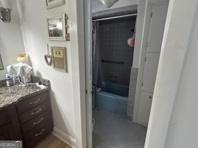 full bath with vanity, shower / bath combo with shower curtain, and baseboards