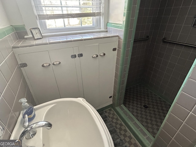 bathroom featuring tile walls and a stall shower