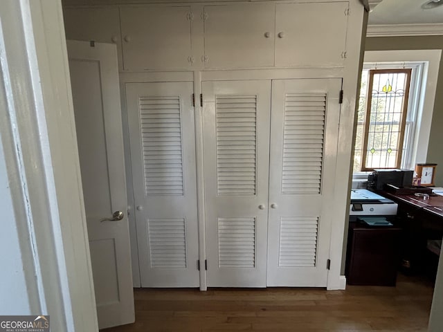 interior space with wood finished floors and ornamental molding