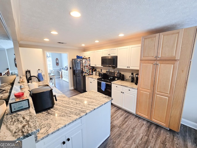 kitchen featuring light stone counters, dark wood-style flooring, crown molding, a textured ceiling, and black appliances