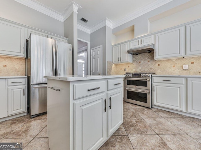 kitchen with stainless steel appliances, light countertops, ornamental molding, and under cabinet range hood